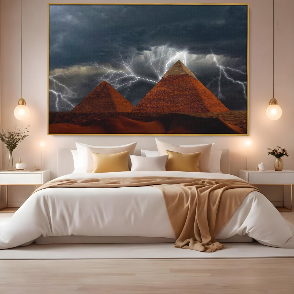 Tablou canvas cu ilustratie cu piramide si fulgere, in rama de aluminiu auriu, pe perete intr-un dormitor